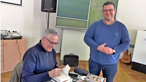 Der Autor Frank Maria Reifenberg beim Signieren mit dem Fachleiter Deutsch des OHG, Patrick Glückler (rechts). Foto: Barbara Rennig