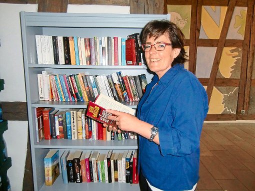 Simone Kies bestückt das Büchertauschregal im Eingangsbereich des Dietinger Rathauses. Foto: Baur Foto: Schwarzwälder-Bote
