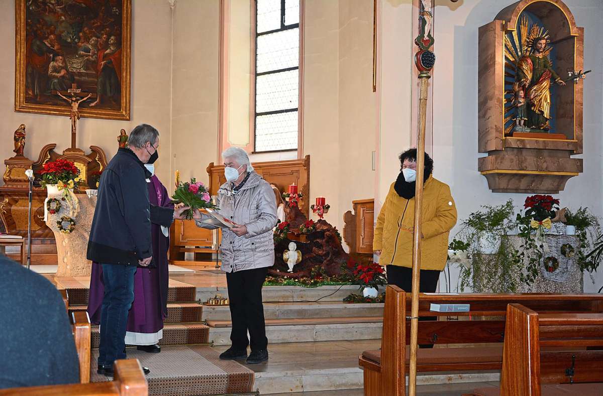 Der Kirchenbeiratsvorsitzende überreicht Elisabeth Butz eine Ehrung für ihr Engagement. Auch ihre Tochter Diana Butz (rechts) wird für zehn Jahre im Mesnerinnendienst geehrt. Quelle: Unbekannt