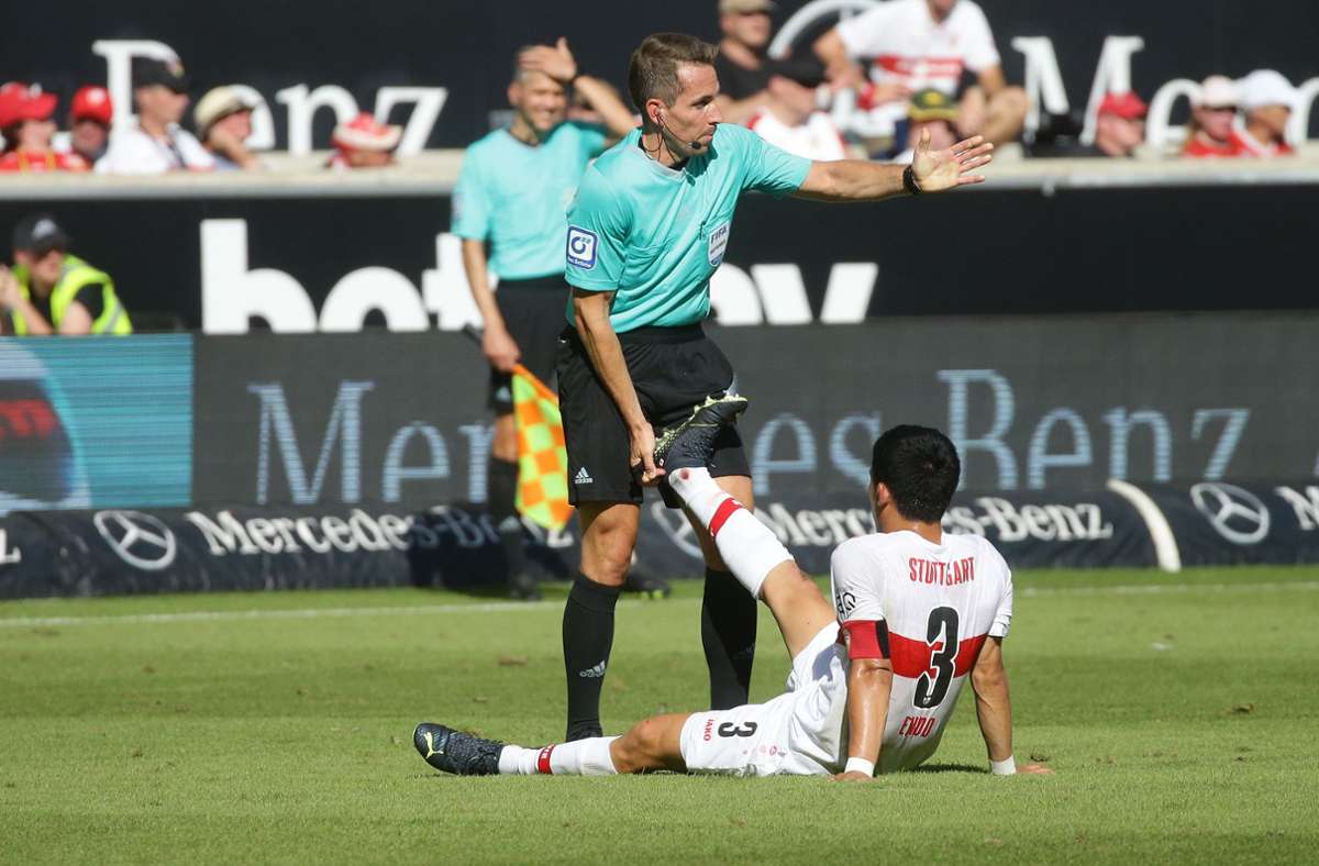 Erste Hilfe: Wataru Endo vom VfB Stuttgart plagt ein Wadenkrampf – und der Schiedsrichter Tobias Stieler greift ein. Foto: Baumann/Hansjürgen Britsch