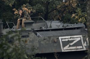 Ein ukrainischer Soldat sitzt auf einem russischen Panzerfahrzeug mit dem Kriegszeichen Z. Foto: dpa/Kostiantyn Liberov