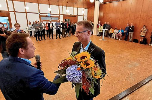 Markus Treiber, Vorsitzender des Gemeindewahlausschusses, überreichte Wahlsieger Schaack einen Blumenstrauß. Foto: Kugel