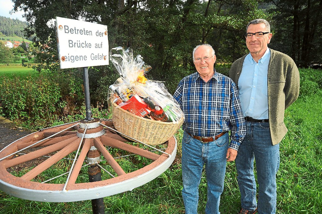 Der Geehrte, Manfred Walz (links), mit Ortsvorsteher Bruno Bessey an einem von zwei Wagenrädern, die Walz angebracht hat. Fotos: Katz­maier