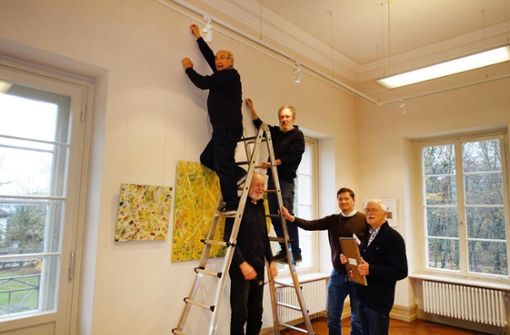Fünf Männer und eine Leiter: Beim Aufhängen der Arthothek-Bilder am Mittwoch. Auch der neue Kreisarchivarchivar Uwe Wolfarczny, der die Schau nun betreut, war bei der Aktion dabei. Foto: Stopper