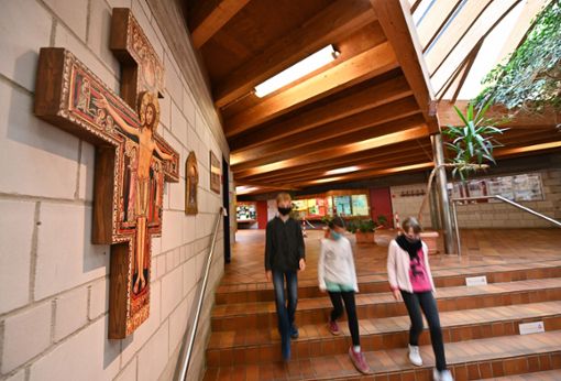 Schüler gehen an einem Kreuz in der Franz von Assisi-Schule in Waldstetten vorbei. Das Gotteskreuz soll die christliche Ausrichtung der katholischen freien Realschule symbolisieren. Foto: dpa