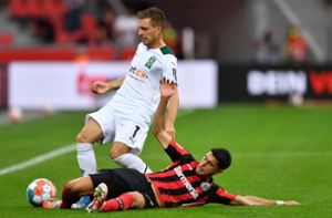 Gladbachs Patrick Herrmann (l) in Aktion gegen Leverkusens Exequiel Palacios. Foto: dpa/Marius Becker