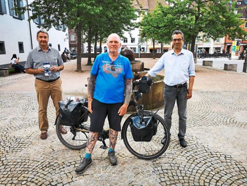 Oli (Mitte) macht auf seiner 5500 Kilometer langen Tour mit dem E-Bike  einen Stop in Villingen und informiert  Bürgermeister Detlev Bührer (links) und  Patrick Chaparro, Leiter der  Tourist-Information,  über seine Projekte zugunsten von krebskranken Menschen. Foto: Schimkat