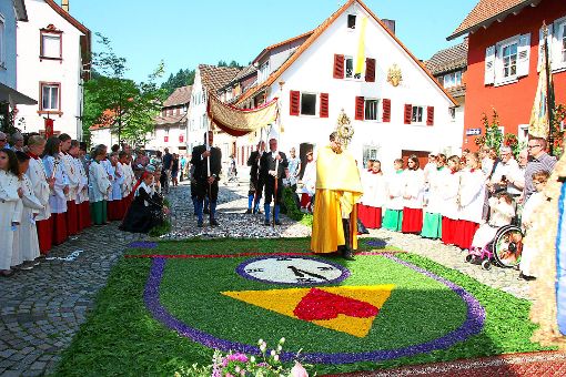 Pfarrer Hannes Rümmele betritt Fronleichnam-Teppich in der Grabenstraße.   Foto: Bea