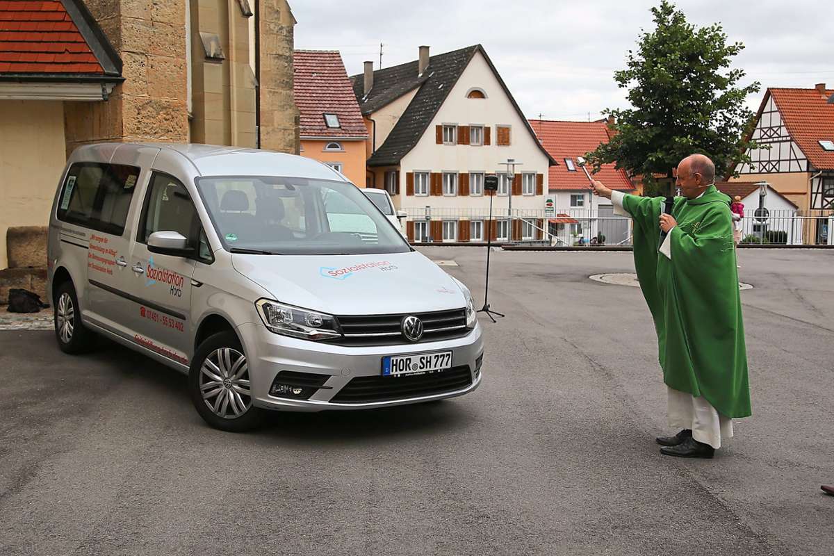 Pfarrer Elmar M. Morein weiht das neue Fahrzeug vor der Nordstetter Kirche.