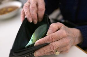 Eine ältere Frau öffnet ihr Portemonnaie. Frauen kommen nach 45 Versicherungsjahren auf eine Rente von durchschnittlich 1323 Euro pro Monat. Foto: Stephanie Pilick/dpa/Stephanie Pilick
