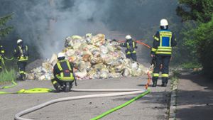 Unter Atemschutz löschen die Feuerwehrleute die brennenden Abfallsäcke.   Foto: Feuerwehr