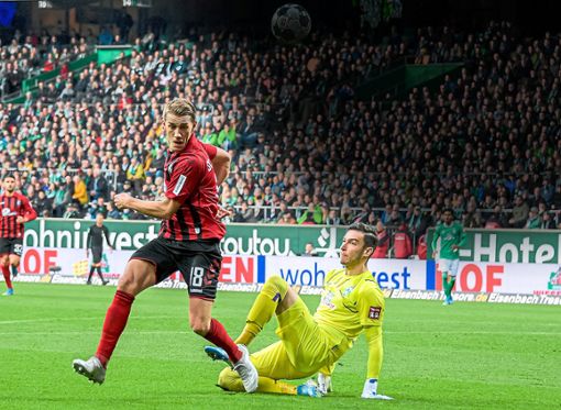Beim 1:1 gegen Bremen wurde SC-Torjäger Nils Petersen (links) von Werder-Keeper Jiri Pavlenka tatkräftig unterstützt. Foto: Anspach
