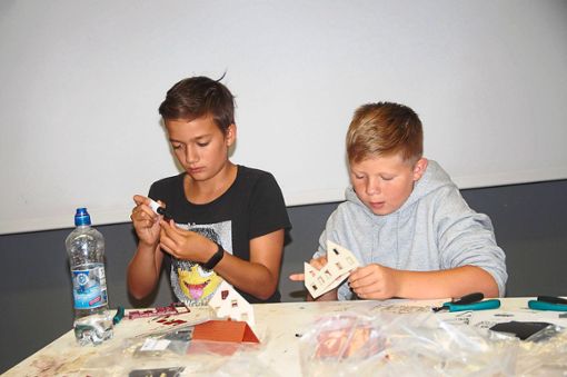 Zum Abschluss des Besuchs bei den Gebrüder Faller in Gütenbach können die jungen Studenten der Kinderuni Furtwangen auch ihr eigenes Häuschen zusammenbauen.  Foto: Heimpel Foto: Schwarzwälder Bote