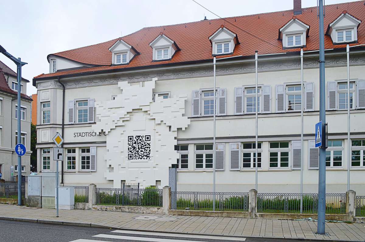 Die weltgrößte Kuckucksuhr des Künstlers Olsen hängt an der Fassade der Städtischen Galerie Villingen-Schwenningen. Beim Scannen des QR-Codes öffnet sich dem Betrachter eine bunte Kuckucksuhren-Welt. Foto: Kratt