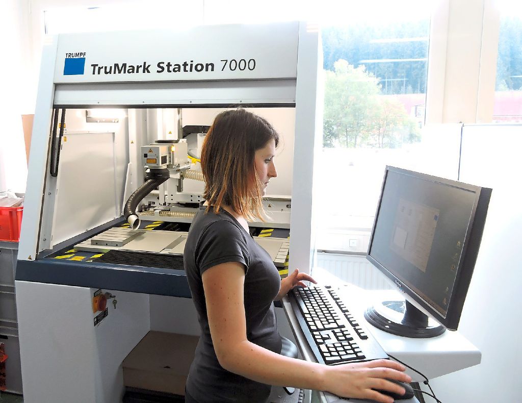 Siedle-Mitarbeiterin Kristina Kern bedient die neue Maschine für Laserbeschriftung. Foto: Siedle