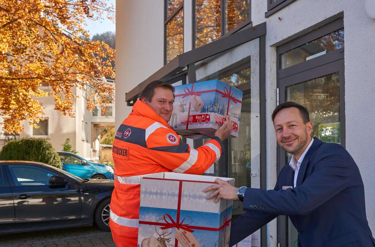 Marius Friedrichson von den Johannitern und Jochen Letsch vom AOK-Kundencenter haben die Weihnachtstruck-Pakete griffbereit für Spender. Foto: Lück