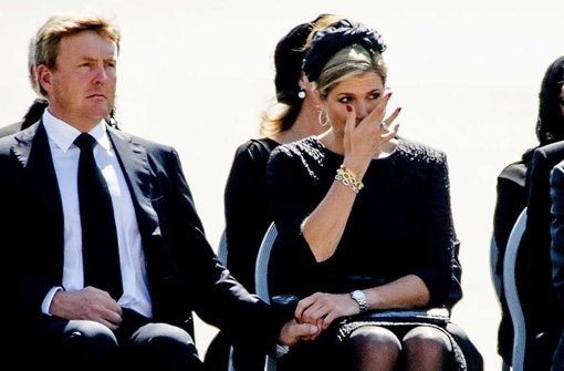 Königin Máxima wischt ihre Tränen ab, König Willem-Alexanders Miene ist versteinert: Am Flughafen von Eindhoven empfängt das niederländische Königspaar die Toten des abgeschossenen Fluges MH17. Foto: dpa