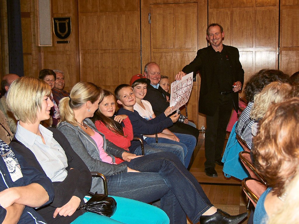 Zauberkünstler Arnd Röhm sorgt bei Besuchern für verblüffte Gesichter, als er herausbekommt, an welche Zahl Julian Gottschalk gedacht hat.  Foto: Frommann Foto: Schwarzwälder-Bote