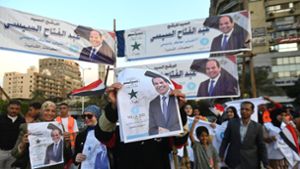 Menschen halten in Kairo Plakate des ägyptischen Präsidenten al-Sisi und feiern seinen Wiederwahlsieg. Foto: dpa/Mohamed Shokry