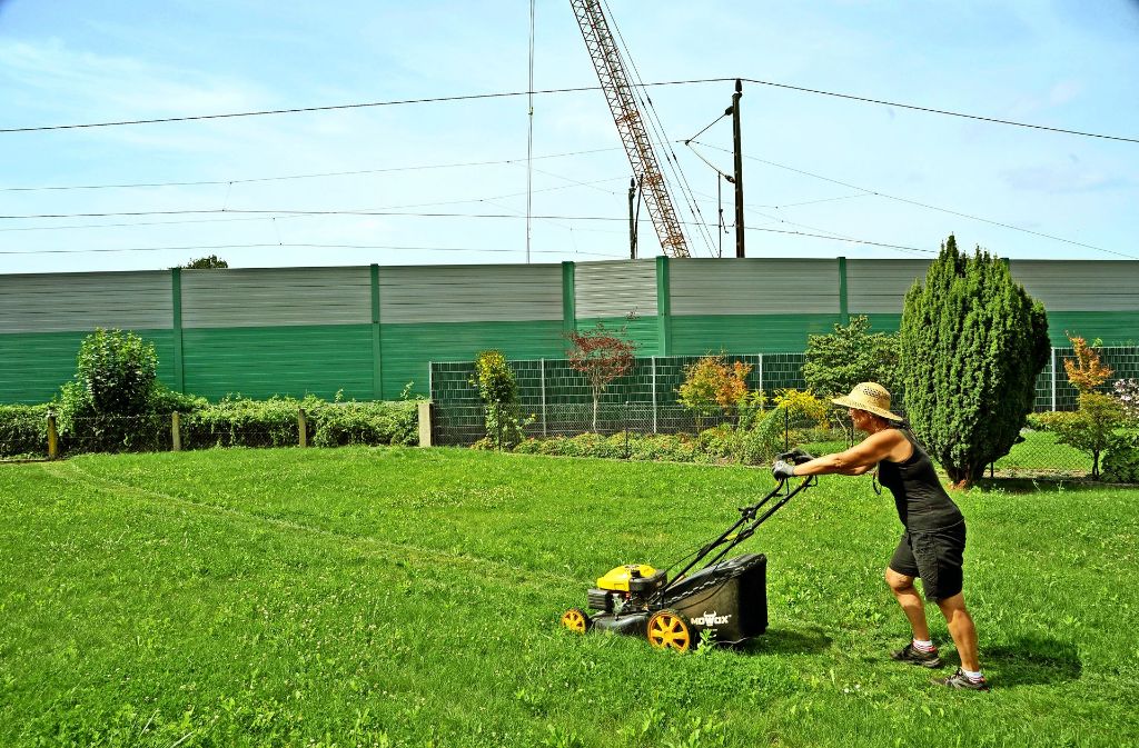 Monika M. bei der Gartenarbeit:   normalerweise tönt hinter der Lärmschutzwand an der Rheintaltrasse nicht nur der Mäher. Foto: Jehle