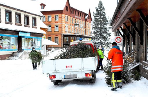 In der Hauptstraße sammeln die Jugendleiter der Freiwilligen Feuerwehr Schönwald unter der 2G-plus-Regel die Bäume mit dem Anhänger des Bauhofs ein. Foto: Kommert