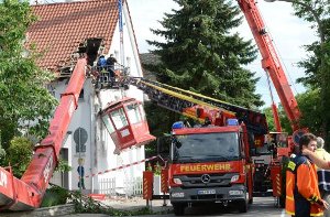 Der Kran, der am Samstag bei einem Schulfest in Neuenstadt bei Heilbronn in ein Haus gestürzt ist, ist in der Nacht zu Sonntag von der Feuerwehr geborgen worden. Foto: dpa