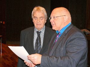 Helmut Reitemann (rechts) liest aus der Urkunde vor, die das Ausscheiden von Hans Uhl besiegelt.  Foto: Hauser