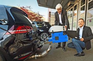Dirk Naber (li.) und Andreas Kufferath arbeiten bei Bosch am sauberen Diesel. Das Bild zeigt eines der Testfahrzeuge mit Abgasmessgerät, das luftdicht mit dem Auspuff verbunden ist. Foto: Ralf Grömminger