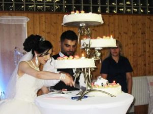 Die Braut schneidet die Hochzeitstorte an, die sich dann die Gäste munden lassen.  Foto: Göttling
