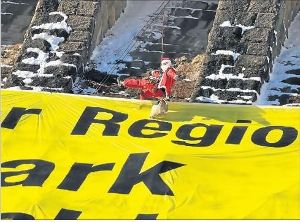 Spektakuläre Aktion an der Staumauer der Schwarzenbach-Talsperre: Greenpeace-Aktivisten enthüllten gestern ein Riesenbanner. Und der Greenpeace-Nikolaus seilte sich ab. Foto: Schwark