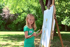 Die siebenjährige Sophia malt auf der Wiese vor dem Kunstzelt Bilder, die sich um das Thema Bewegung drehen. Fotos: Smaoui Foto: Schwarzwälder-Bote