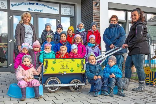 Die 17  Kinder des Bad Imnauer Kindergartens St. Josef  und ihrer Erzieherinnen (von links) Evelyn Vogt, Andrea Strobel und Lydia Budzinski freuen sich über den neuen elektrisch angetriebenen Bollerwagen.Foto: Haid Foto: Schwarzwälder Bote