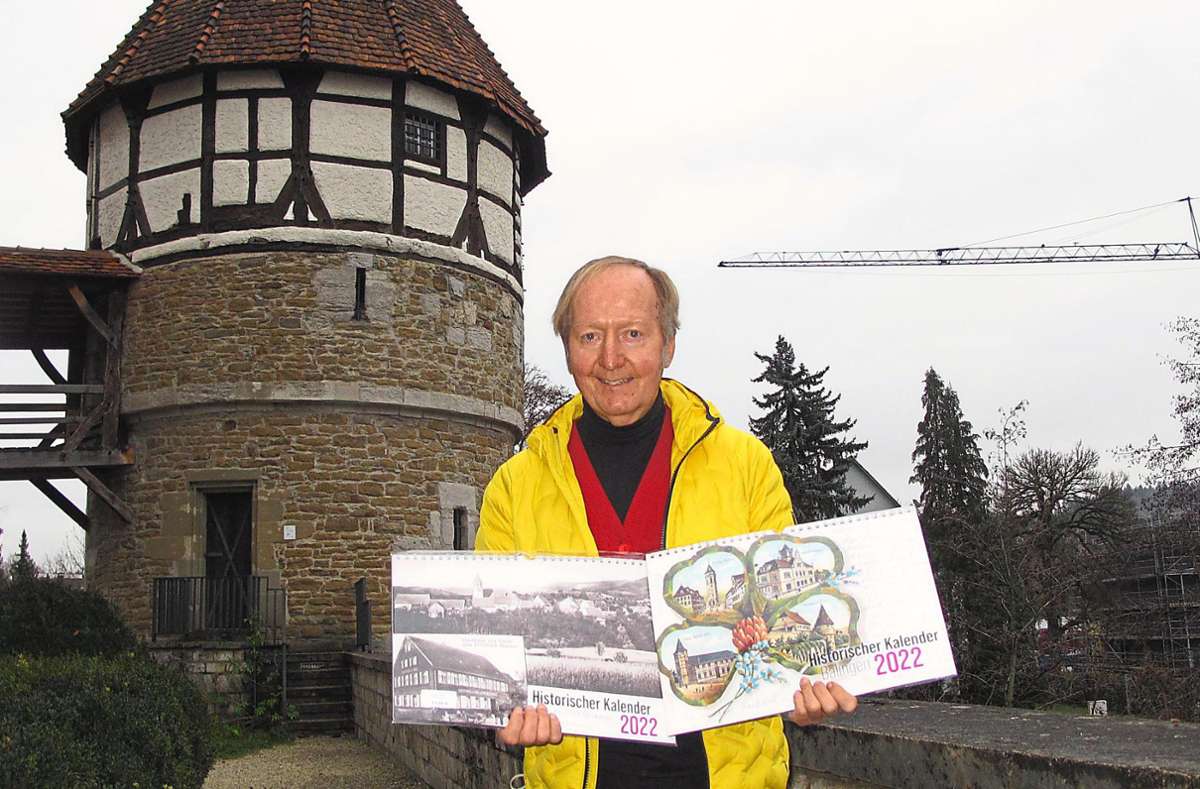 Vor dem Wasserturm hält Günther Meinhold die aktuellen Ausgaben der Historischen Kalender in den Händen.