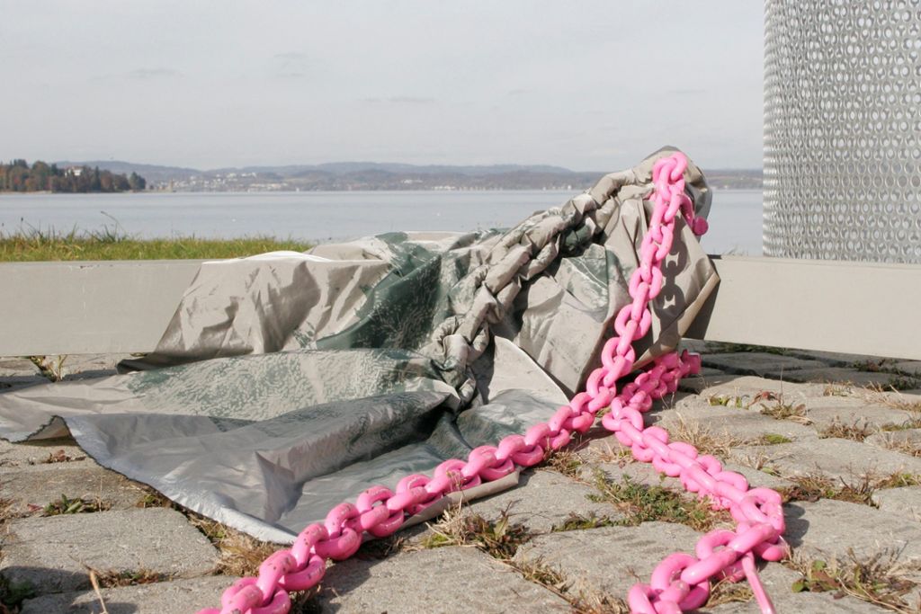 Am Konstanzer Hafen versieht die Künstlerin eine Kette mit einer textilen Erweiterung.