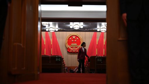 Eine Frau geht durch den Plenarsaal der Großen Halle des Volkes in Peking. Chinas Wirtschaft soll nach dem Willen der Regierung in diesem Jahr um rund fünf Prozent wachsen. Foto: Johannes Neudecker/dpa