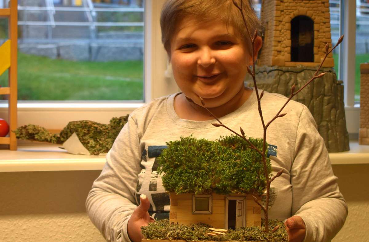 Stolz präsentiert Benito sein selbst gemachtes Holzhaus. Es soll ihn zuhause an den Schwarzwald erinnern. Foto: Katharinenhöhe
